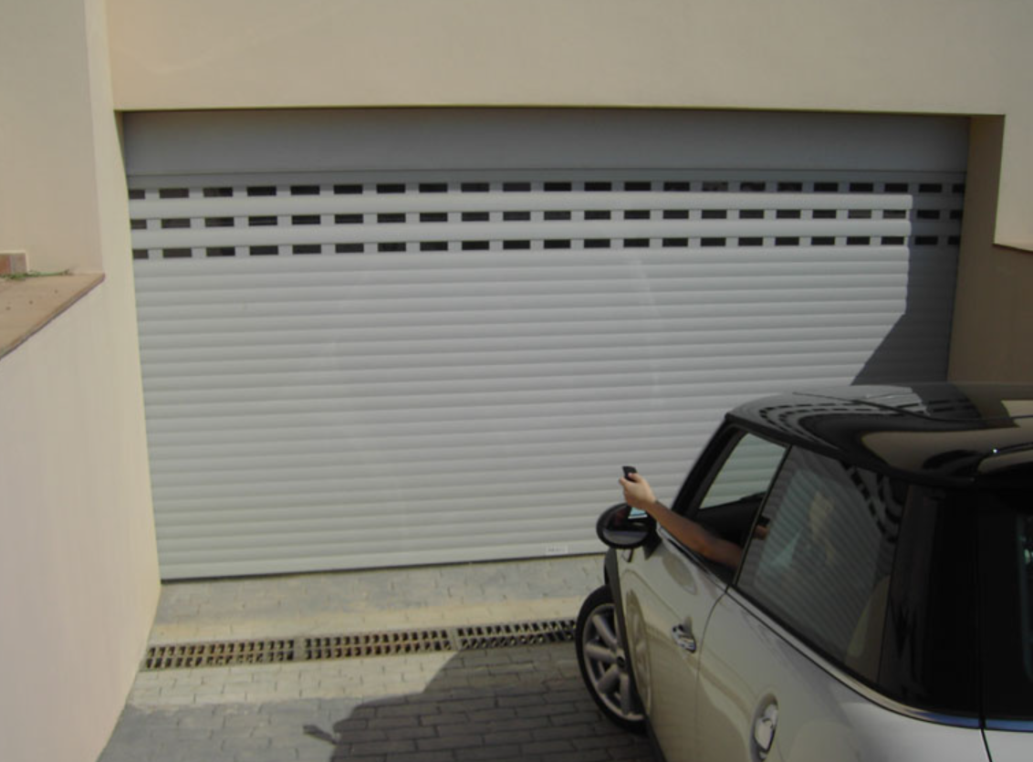 Porte de garage enroulable blanche ouverte à la télécommande depuis une voiture