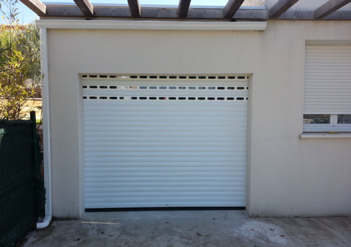 Porte de garage enroulable blanche avec lames à hublots sous une pergola