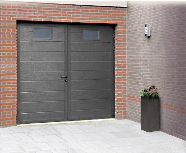 Porte de garage battante grise à deux vantaux sur une façade en brique