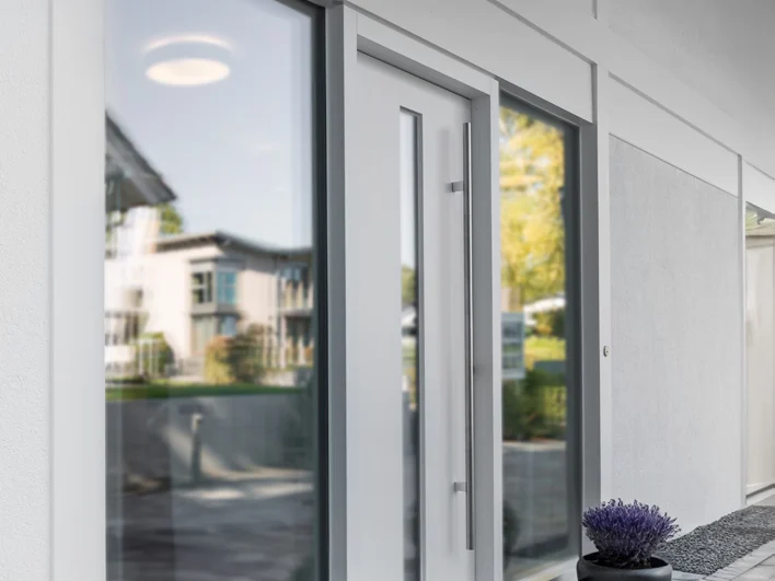 Porte d'entrée aluminium grise avec grande barre de tirage et fixes vitrés