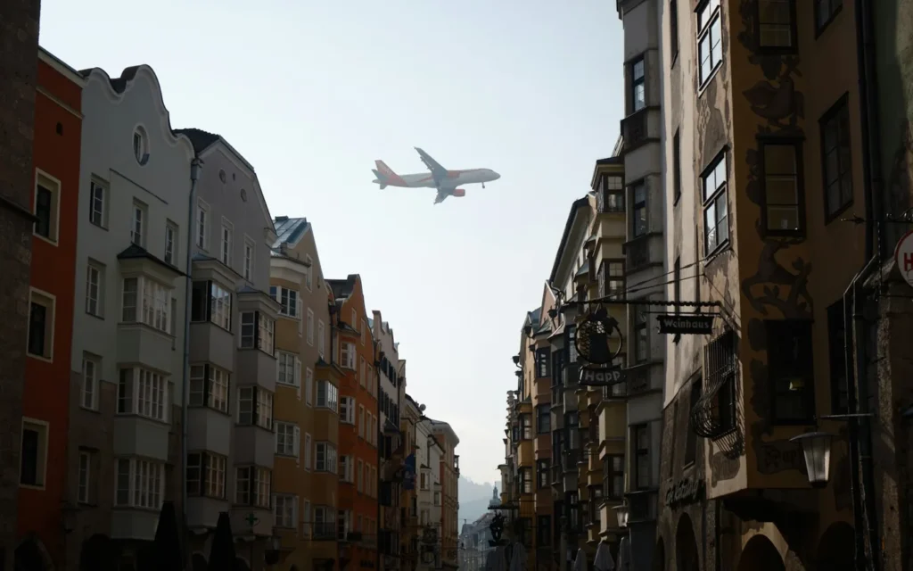 Avion de ligne survolant une rue bordée de maisons