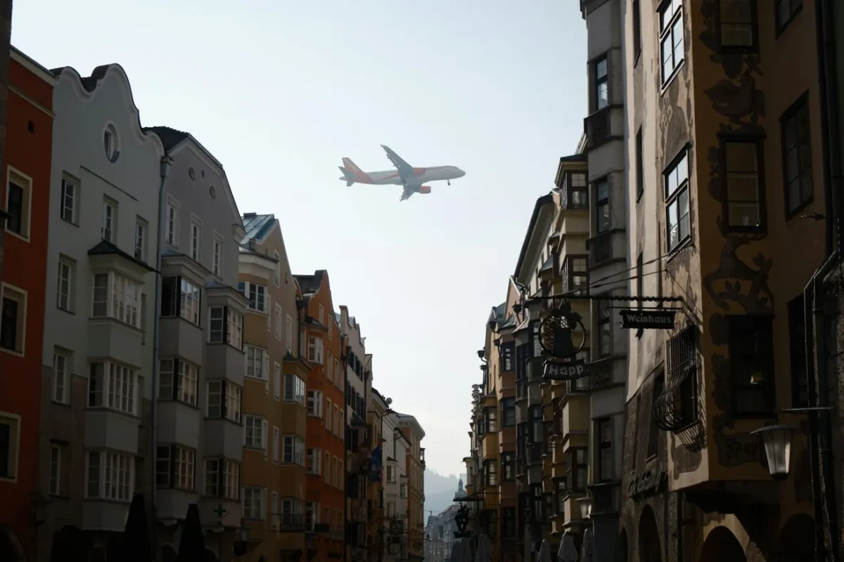 Avion de ligne survolant une rue bordée de maisons