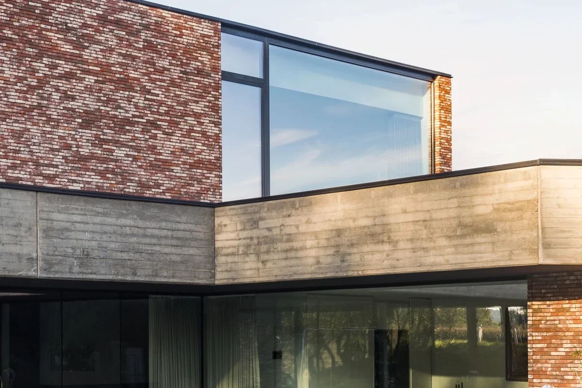 Maison contemporaine en brique avec grandes fenêtres aluminium sombres