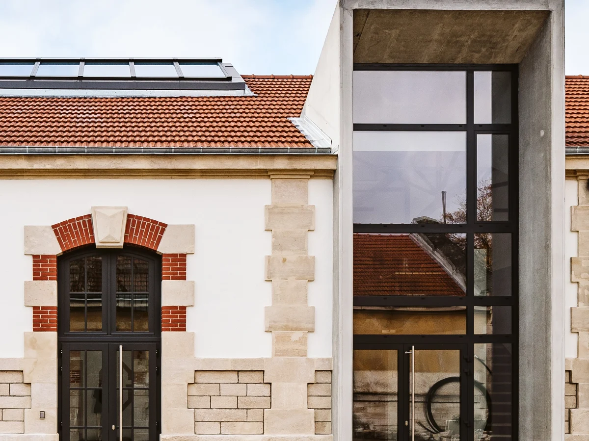 Grande verrière aluminium noire style atelier sur une maison ancienne en pierre
