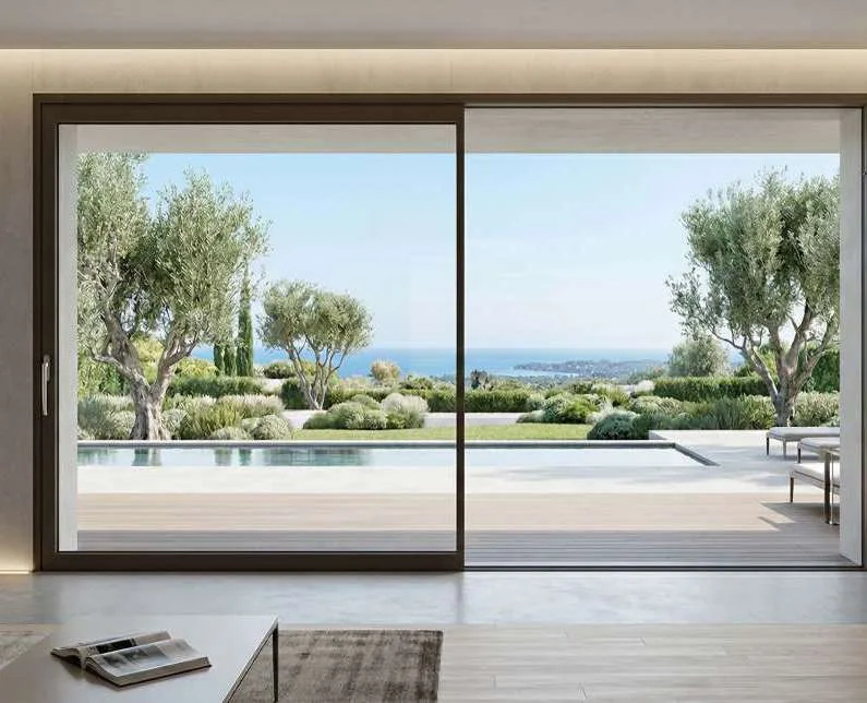 Grande baie levante-coulissante aluminium ouverte sur une terrasse avec piscine