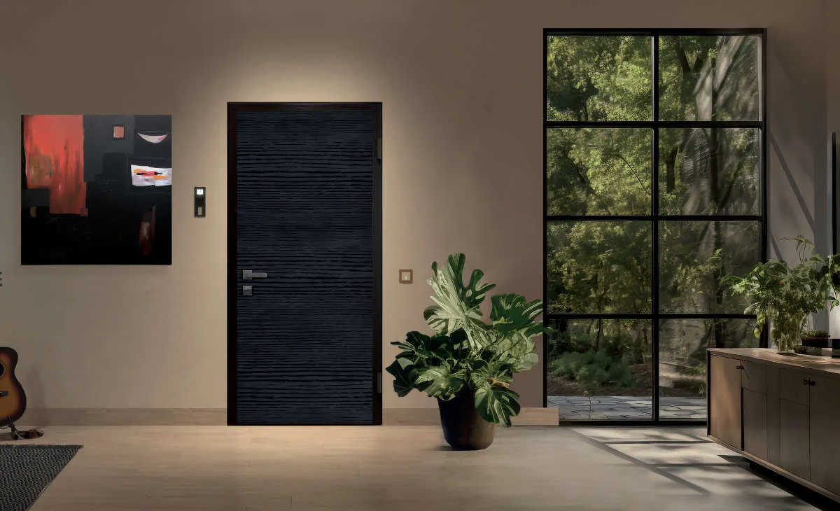 Porte blindée noire à paumelles visibles dans une entrée contemporaine
