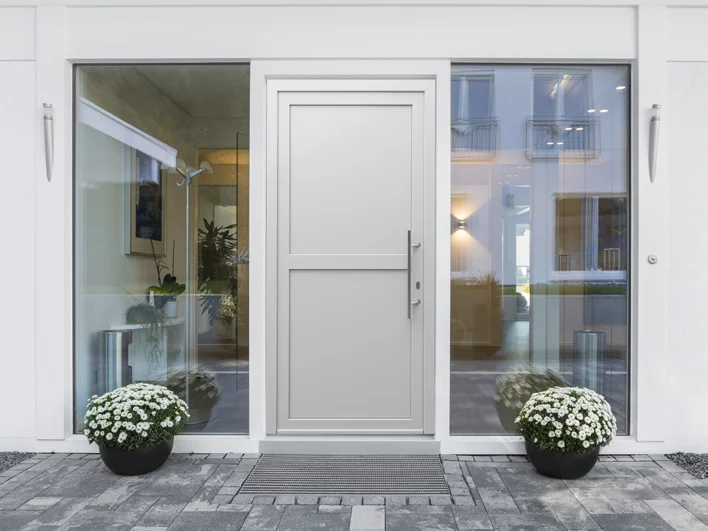 Porte d'entrée PVC blanche avec deux fixes vitrés latéraux, façade moderne